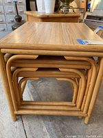 Set of three bamboo nesting tables stacked inside each other showing the nesting feature and bamboo tube frame