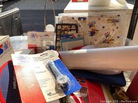 Photo showing various pieces of Olympic themed memorabilia including hats, pins, posters, and the packaged LCD quartz watch.