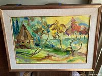 Framed full view of multi colored village themed original painting by Natalie.