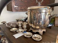 Overview of 3 sterling silver cups with mini saucers and a silver-plated ice bucket showing decorative details.