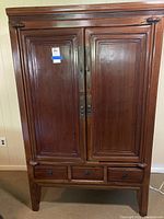Front view of full armoire showing two doors and three drawers.