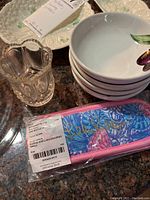 Photo showing small glass pitcher, Belleek ceramic bowls with plum motif, and Blue Haven bristle brush in packaging