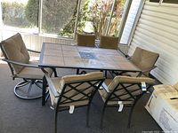 Full set view showing rectangular tile-top table and six chairs on enclosed porch