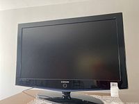 Front view of Samsung 40-inch TV with black bezel and round swivel stand.