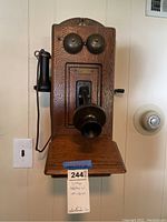 Front view of oak wall-mounted telephone showing bells, mouthpiece, earpiece and shelf
