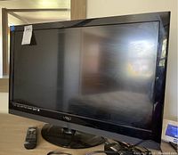 32-inch Vizio HDTV with accompanying remote control and power cable, front angled view.