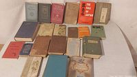 Photo showing full lot of antique books, 19 volumes with various bindings and wear consistent with age.