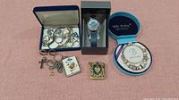 Full lot inventory showing Timex watch box, jewelry box with rings, bracelets, earrings, cross necklace, two decorative lockets, and Bella Perlina bracelet box.