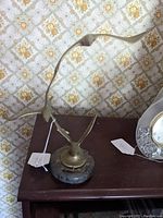 Front view of brass bird sculpture on table showing three birds mounted on marble base