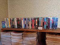 Wide shelf view of sealed VHS tapes arranged on a wooden shelf
