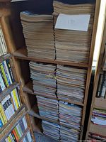 Shelf stacked with four columns of vintage magazines, roughly 190 issues noted on a paper.