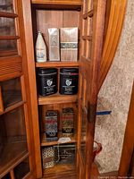 Wide view of cabinet shelf showing Old Spice bottle, Bergdorf Goodman Edmonton boxes, Russian Leather kits, Black Belt boxes, Hai Karate gift set and Givenchy Gentleman
