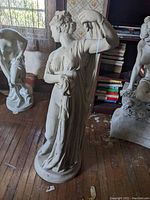 Front and side view of cast resin statue showing detailed front drapery and figure.