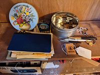 Shelf view showing mixed lot items including fountain pen, ephemera, pins, Boston Police patch, and tin