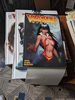 Photo of Vampirella Strikes book over a stack of other Vampirella books.