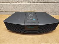 Front view of black Bose Wave Radio showing digital clock display and front speaker grille.