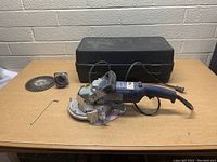 Crain undercut saw fully displayed with carrying case, spare blade, and allen wrench on table.