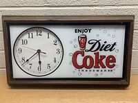 Front view of Diet Coke wall clock with clear display of clock face and branding.