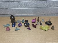 Photo showing the entire lot of assorted crystals and mineral specimens laid out on a table against a brick wall.