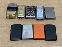 Full view of all 8 assorted lighters laid out in two rows on wooden surface.