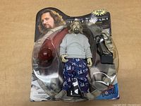 Three unopened Big Lebowski action figures showing different head sculpts and accessories in original packaging with character image and Urban Achiever branding.