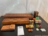 Wide view of entire lot including two cribbage boards, multiple dice sets, leather card cases, and dice cup.