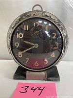 Front view of Westclox Big Ben vintage alarm clock showing black dial with gold numbers and hands, and alarm dial at top center. Heavy paint wear on round casing and base.