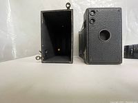 Vintage box camera disassembled showing internal and external views.