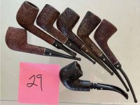 Top view showing all seven used smoking pipes with varying bowls and stems, some with systems or condensers