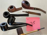 Photo showing six smoking pipes in various finishes and shapes