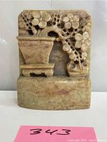 Front view of soapstone bonsai bookend showing carved floral bonsai tree in pot on a rectangular base.