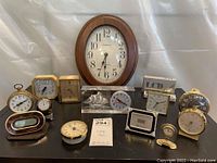 Photo showing full assortment of vintage alarm clocks and small desktop clocks of various shapes and styles