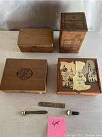 Overview of four vintage wooden boxes including branded Corina Larks, El Producto Queens, Royal Mana decoupaged box, and plain box, along with three cigar tools.