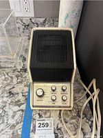 Front view showing overall device shape, control knobs, and power cord