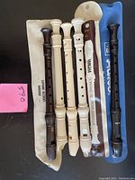 Five Yamaha soprano Baroque recorders in cream and brown plastic arranged on several cloth pouches, with one black plastic recorder (AULOS) and a Chinese wood flute included in the lot.