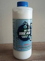 Front label of a 2lb bottle with blue cap, showing 99% pure boric acid branding and warning labels.