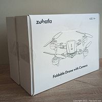 Photo of two unopened Zuhafa foldable drone boxes showing product name and image.