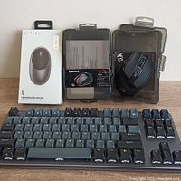 The lot displayed with a black wireless gaming keyboard, boxed Satechi M1 wireless mouse, and two Redragon Sniper Pro mice in open plastic packaging with one mouse visible.