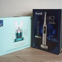 Two boxed electric toothbrushes side by side: Wekome U-shaped toothbrush and Oral-B iO Series 9 toothbrush boxes.