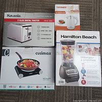 Full set of boxed kitchen appliances: blender, toaster, hot plate, and travel kettle