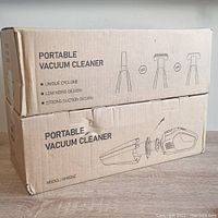 Closed cardboard box showing packaging and product features: portable vacuum cleaner, unique cyclone, low noise, strong suction, model HM036E.