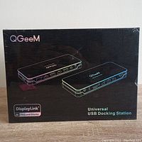 Front view of sealed QGeeM docking station box showing product image, brand, and key features