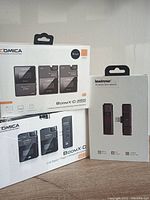 Photo showing factory packaging of Comica Boom X-D, Boom X-D Pro wireless microphone systems, and Lewinner wireless microphone.