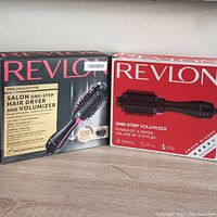 Photo of two boxed Revlon one-step hair dryer and volumizer units, one from Pro Collection with ceramic coating and ionic technology.