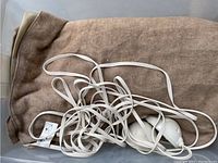 Brown queen size electrical blanket folded with attached white control cord and unit.