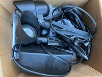 Photo of the three black plastic landscape lights and cables inside a cardboard box