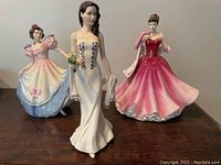 Front view of three figurines on table showing colors, poses and details