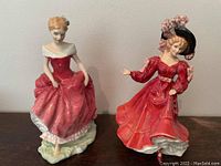 Front view of two Royal Doulton figurines showing detailed dresses and poses.