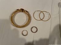 All four items laid out: bangle, hoops, two rings