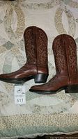 Full side view of both brown cowboy boots showing overall shape, heel, and stitching.